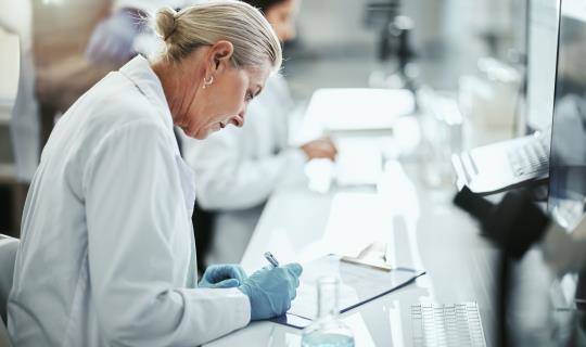 Woman researcher writing note on pad