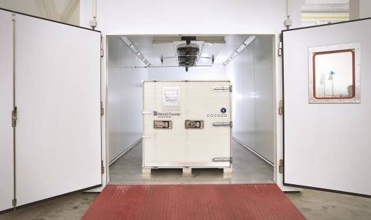 A cocoon shipping container sits inside a large climate chamber inside CORE Labs.