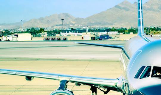 A closeup view of a jet plane sitting at a gate, ready to be loaded.