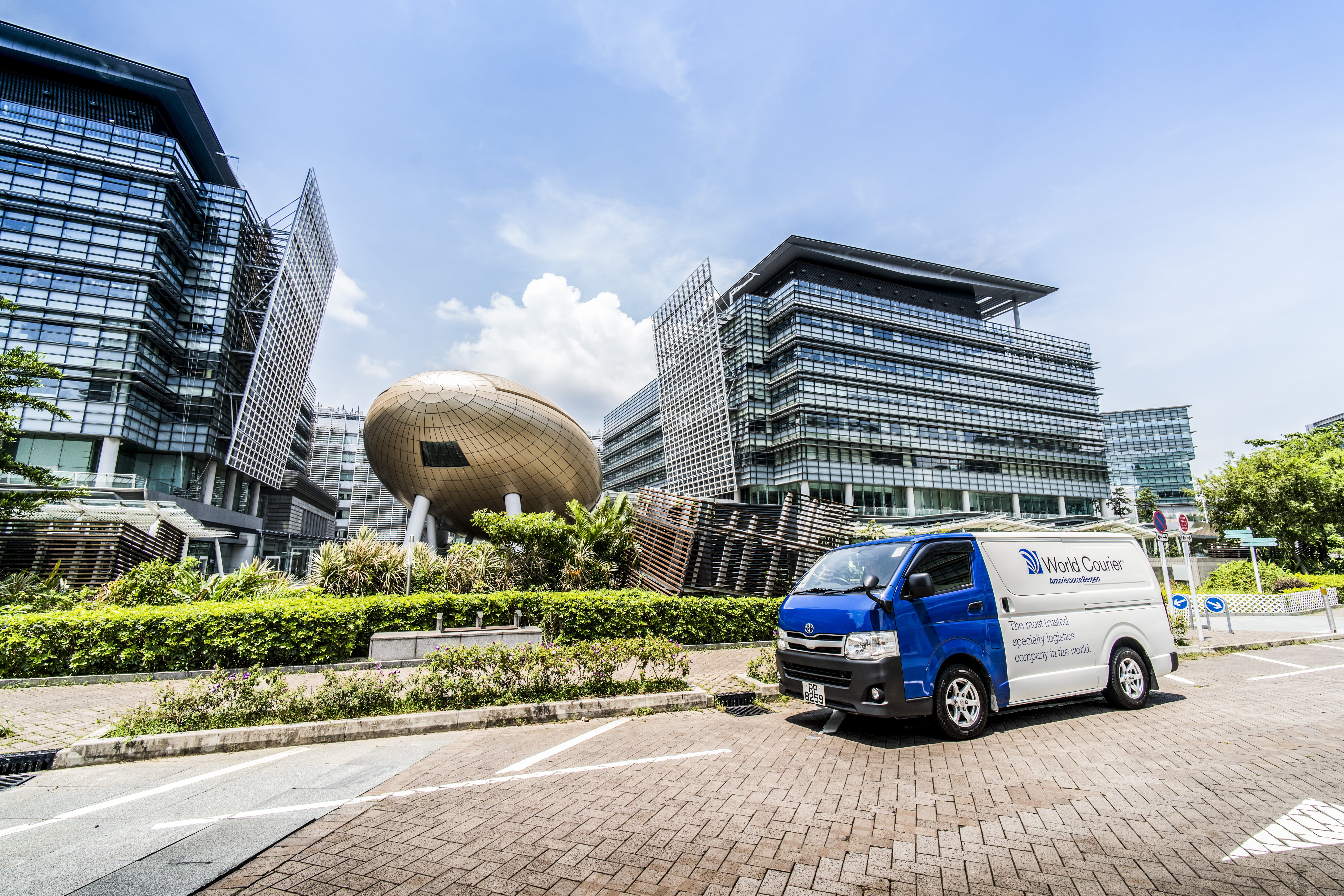 A World Courier van is parked in front of a city skyline