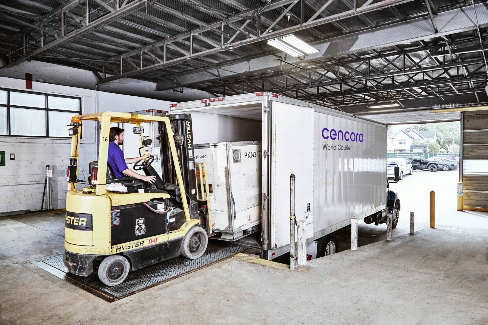 World Courier delivery truck being loaded by a forklift on a loading dock