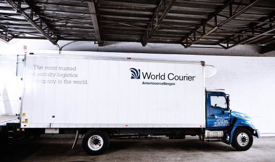 A large World Courier truck, or lorry, parked at a loading dock.